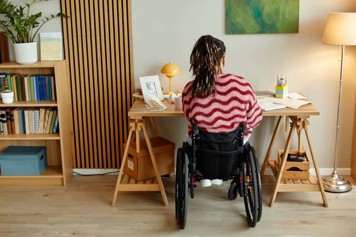 Photographie qui montre une jeune femme en situation de handicap en télétravail