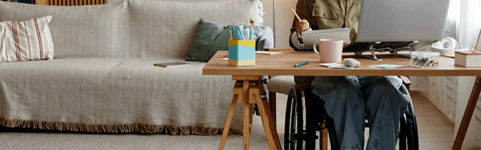 Photo qui montre une femme en situation de handicap dans un fauteuil roulant en train de travailler à distance