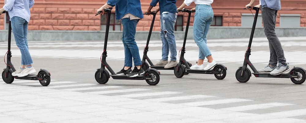 Photo de plusieurs salariés roulant en trottinettes électriques