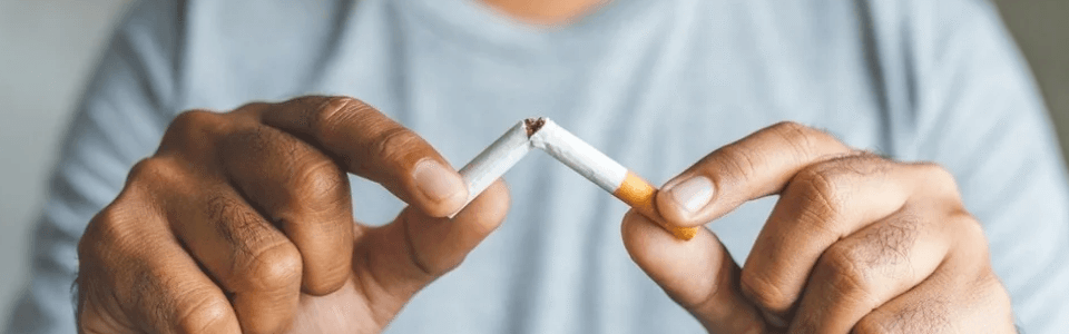 Illustration d'un salarié cassant une cigarette en deux pour représenter l'arrêt du tabac et le sevrage tabagique