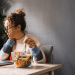 Salariée qui mange une salade équilibrée pour illustrer l'importance d'une bonne alimentation lors de l'arrêt du tabac